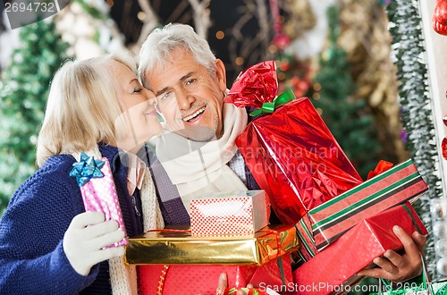 Image of Woman About To Kiss Man Holding Presents