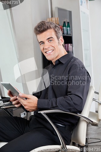 Image of Male Customer With Digital Tablet Sitting At Salon