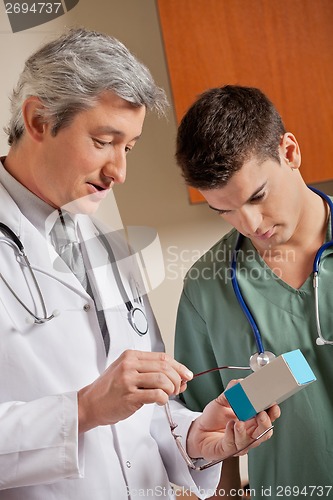 Image of Medical Professionals Looking At Medicine Box