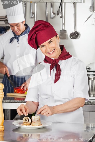 Image of Female Chef Garnishing Salmon Roll