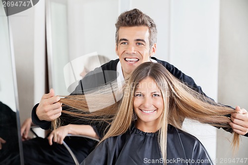 Image of Hairdresser Examining Customer's Hair St Salon