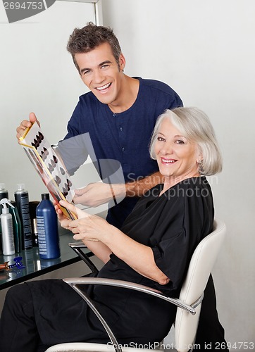 Image of Hairstylist And Client With Color Catalog