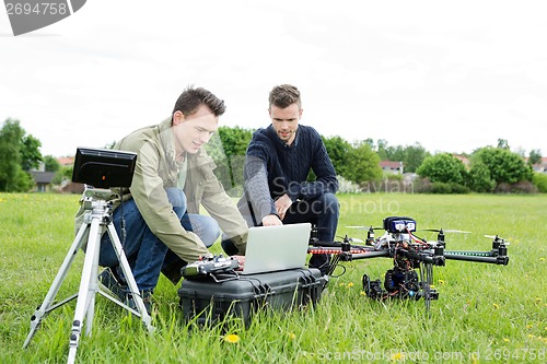 Image of Technicians Using Laptop By Tripod And UAV