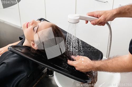 Image of Hairstylist Washing Client's Hair At Parlor