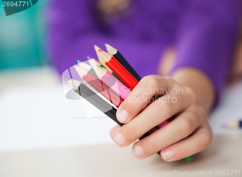 Image of Girl Holding Colored Pencils At Desk