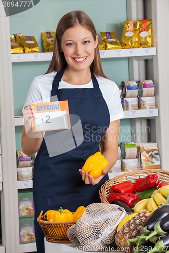 Image of Saleswoman Holding Pricetag And Bellpepper In Supermarket