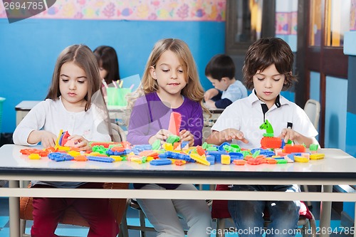 Image of Children Playing With Construction Blocks In Classroom