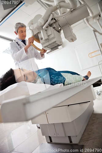 Image of Radiologist Setting Up Machine To X-ray Female