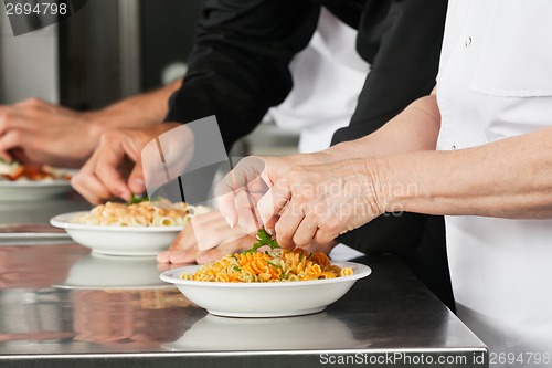 Image of Chefs Garnishing Pasta Dishes