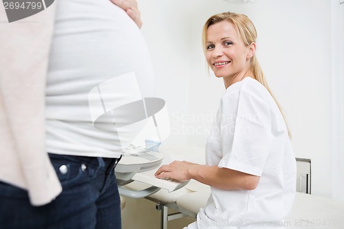 Image of Happy Doctor Using Ultrasound Machine In Clinic