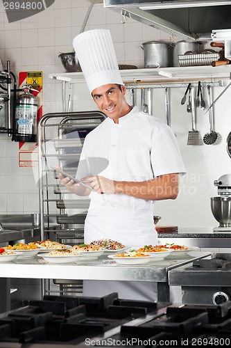 Image of Happy Chef With Digital Tablet Checking List Of Pastas