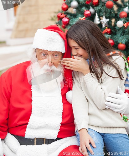 Image of Girl Whispering Wish In Santa Claus's Ear