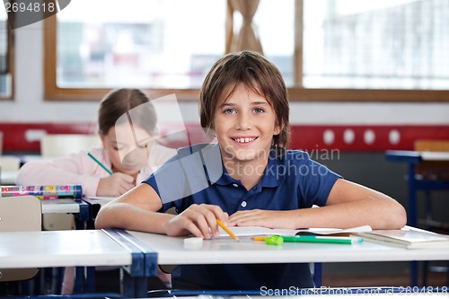 Image of Happy Little Boy Sitting At Desk