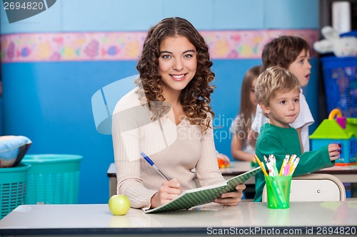 Image of Teacher Writing In Book