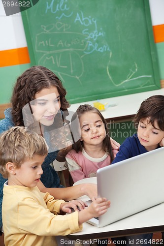 Image of Teacher And Students Using Laptop In Class