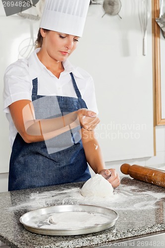 Image of Female Chef Kneading Dough On Counter