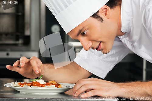 Image of Male Chef Garnishing Dish