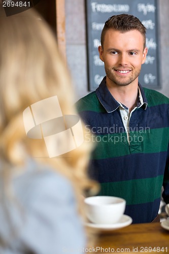 Image of Bartender Serving Coffee To Woman At Cafe
