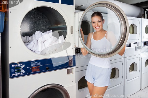 Image of Woman Looking Through Washing Machine Lid