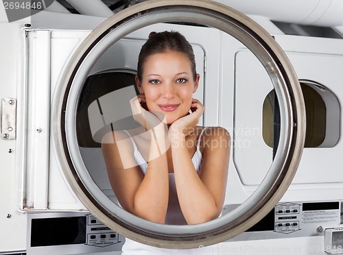 Image of Woman Leaning On Washing Machine Door