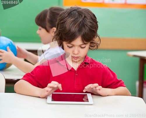 Image of Boy Using Digital Tablet At Desk