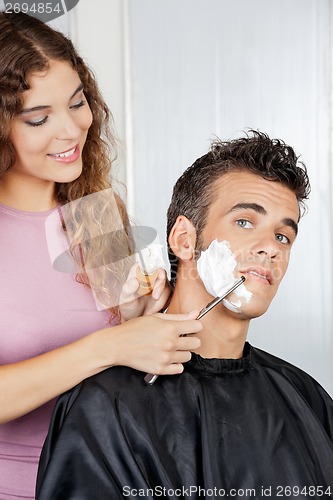 Image of Man Getting A Shave From Female Barber