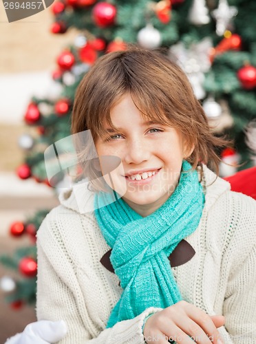 Image of Boy Smiling Against Christmas Tree