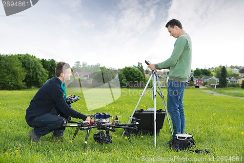 Image of Engineers Working On UAV Helicopter in Park