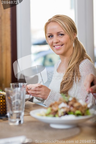 Image of Young Woman Having Food At Coffeeshop