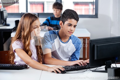 Image of Friends Using Desktop Pc In School Lab