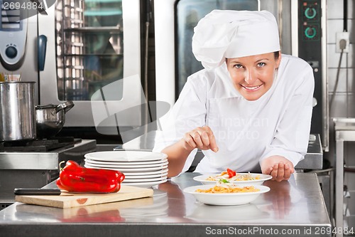 Image of Chef Sprinkling Spices On Food