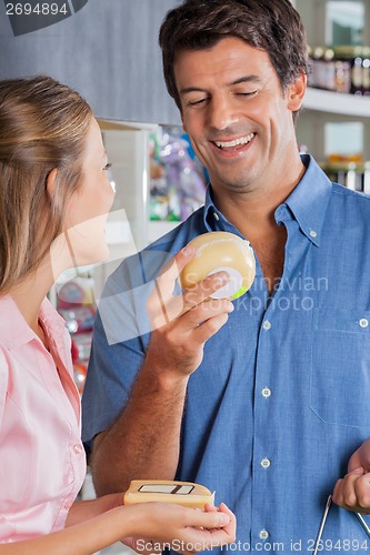 Image of Couple Choosing Cheese At Grocery Store