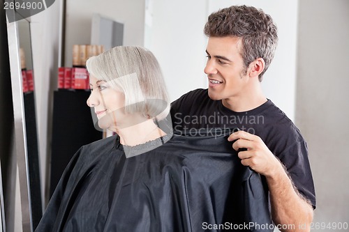 Image of Hairdresser Removing Client's Apron After Haircut