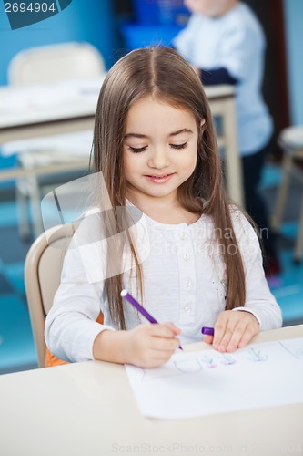 Image of Girl Drawing With Sketch Pen At Desk