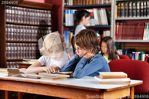 Image of Schoolboys Reading Book Together In Library