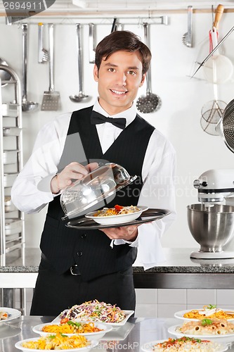 Image of Waiter Lifting The Cover Of Cloche