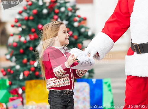 Image of Santa Claus Taking Wish List From Girl