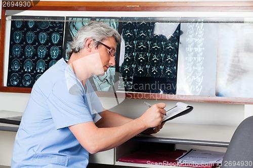 Image of Doctor Writing On Clipboard