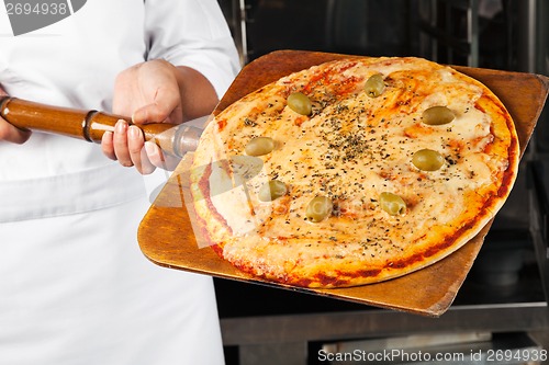 Image of Chef Holding Pizza On Shovel