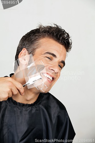 Image of Happy Man Shaving His Face