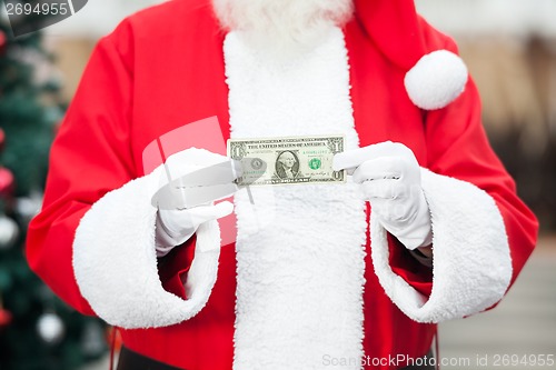 Image of Santa Claus Holding One Dollar Note