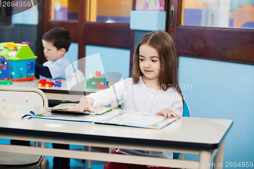 Image of Girl Opening Popup Book at Desk