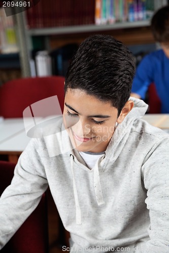 Image of Schoolboy Smiling While Sitting In Library