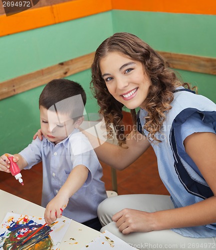 Image of Teacher With Student Painting In Classroom
