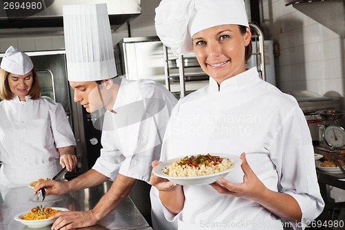 Image of Happy Female Chef Presenting Pasta In Kitchen