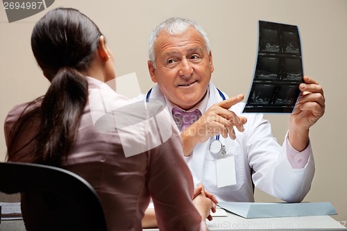 Image of Radiologist Showing X-ray To Patient