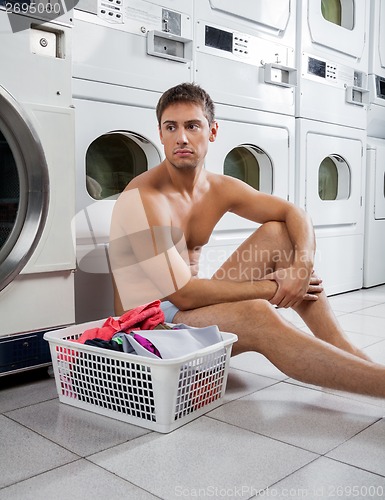 Image of Bored Man With Laundry Basket Waiting To Wash Clothes