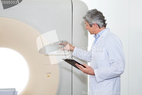 Image of Doctor Operating CT Scan Machine