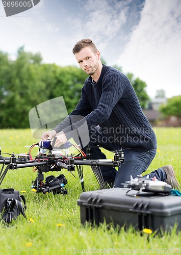 Image of Young Technician Assembling UAV in Park