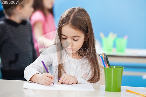 Image of Cute Girl Drawing With Sketch Pen In Classroom